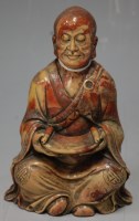Lot 321 - A Chinese carved soapstone figure of a seated...