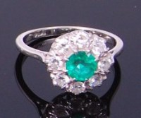 Lot 3293 - A platinum, emerald and diamond flower head...