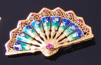 Lot 3294 - An 18ct gold, ruby and enamelled brooch, in...