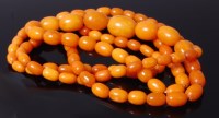 Lot 3321 - *A beaded butterscotch amber single string...