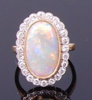 Lot 3421 - An 18ct gold, opal and diamond ring, arranged...