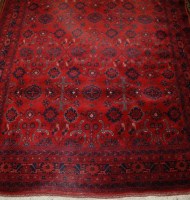 Lot 1520 - A Persian woollen red ground rug, decorated...