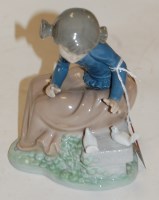 Lot 54 - A small Nao figure of a seated girl with doves,...