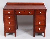 Lot 251 - A late Arts & Crafts oak kneehole desk, having...