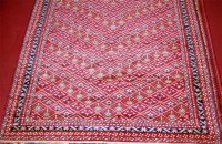 Lot 462 - A Persian woollen rug, the red ground with...