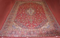 Lot 780 - A large Persian woollen carpet, the red ground...