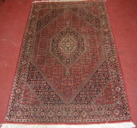 Lot 781 - A Persian woollen red ground rug, having...