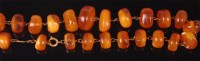 Lot 514 - A beaded amber necklace, the beads of natural...