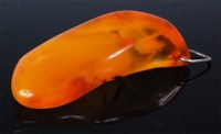 Lot 227 - A heavy amber pendant, with indistinct...