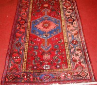 Lot 546 - A Persian woollen rug, the red ground...