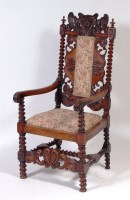 Lot 611 - A Caroleon style carved walnut highback elbow...