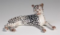 Lot 447 - A porcelain model of a recumbent leopard,...
