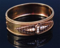 Lot 547 - A circa 1900 gold hinged bangle, having seed...