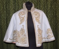 Lot 608 - An Edwardian cream wool cape, with gold metal...