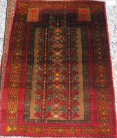 Lot 850 - A Persian woollen prayer rug, having a twin...