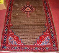 Lot 855 - A Persian woollen brown ground rug, having a...