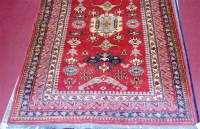 Lot 847 - A Persian Kazak woollen rug, the red ground...