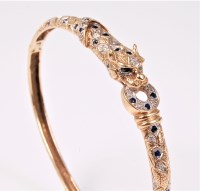 Lot 2553 - A sapphire and diamond bangle, with stylised...