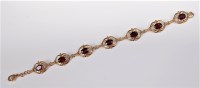 Lot 2556 - A garnet bracelet, the oval faceted garnets...
