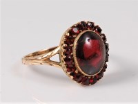 Lot 2645 - A garnet cluster ring, the oval garnet...