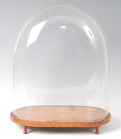 Lot 1616 - A Victorian glass dome on an oval *oak* plinth,...