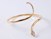 Lot 1162 - A 14ct diamond set upper arm snake bangle, the...