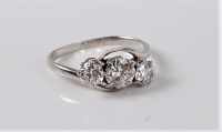 Lot 1197 - A three stone diamond crossover ring, the...