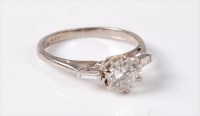 Lot 1223 - A diamond ring, the central round brilliant...