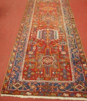 Lot 1457 - A Persian Heriz woollen hall runner, the red...