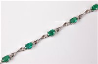 Lot 2240 - An emerald and diamond bracelet, the oval...