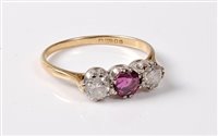 Lot 2284 - An 18ct three stone ruby and diamond ring, the...
