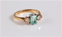 Lot 1172 - An 18ct three stone emerald and diamond ring,...
