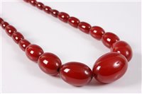 Lot 443 - A faux cherry amber bead necklace, the...
