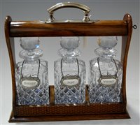Lot 120 - An oak three bottle tantalus with silver...