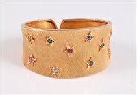 Lot 1190 - An 18ct gemset hinged cuff bracelet, the satin...