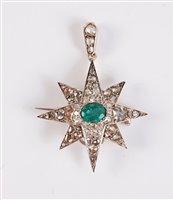 Lot 1218 - An emerald and diamond star pendant / brooch,...