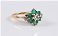 Lot 1191 - An 18ct emerald and diamond cluster ring, the...