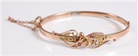 Lot 364 - A 9ct ruby and diamond highlight hinged bangle,...