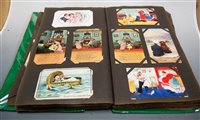 Lot 563 - An early 20th century postcard album and...