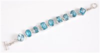 Lot 2639 - A silver and topaz bracelet, the mixed cut...