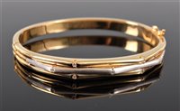 Lot 1233 - An 18k bi-colour gold and diamond hinged...