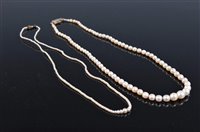 Lot 1316 - Two 'pearl' necklaces, the first a graduated...