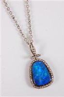 Lot 1255 - A black opal and diamond pendant, the rounded...