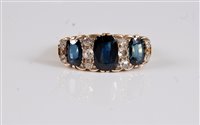 Lot 2593 - An 18ct sapphire and diamond ring, the central...