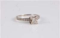 Lot 2623 - A diamond ring, the central round brilliant...
