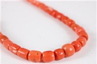 Lot 2571 - A coral bead necklace, the barrel shaped beads...