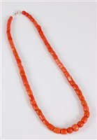 Lot 2571 - A coral bead necklace, the barrel shaped beads...
