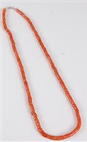 Lot 2572 - A coral bead necklace, the barrel shaped beads...