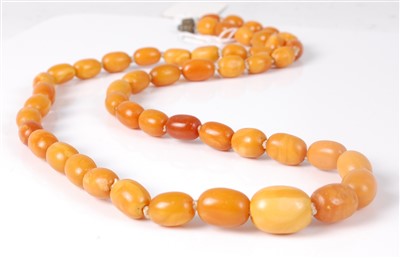 Lot 1275 - A beaded and graduated butterscotch amber...