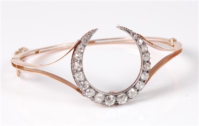 Lot 1269 - A yellow metal and diamond set hinged bangle,...